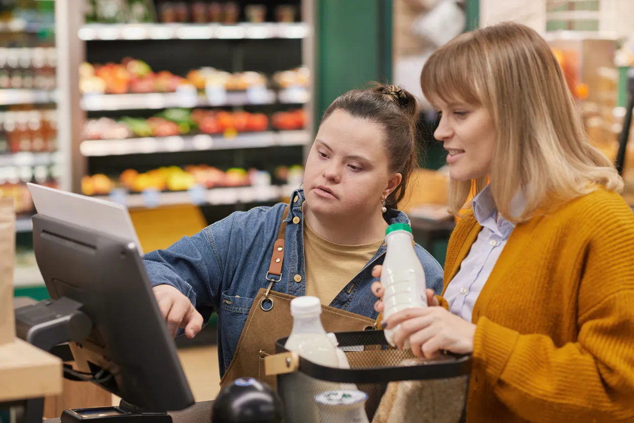 A woman with an intellectual disability helps a customer at a